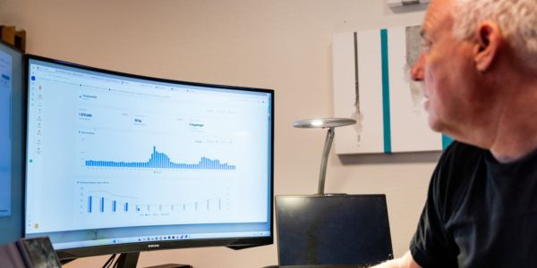 Mann ser på energidata på en skjerm