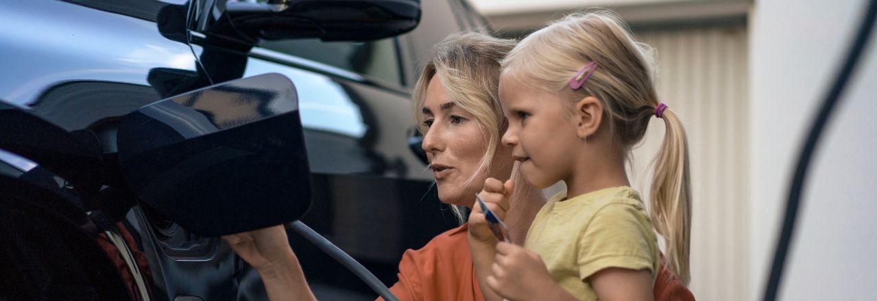 Mor og datter med en elbil som lades