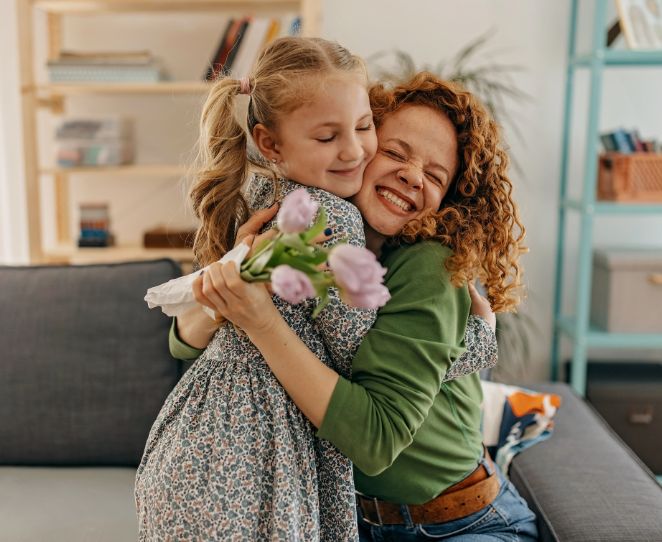 En jente gir blomster og får en klem
