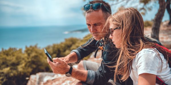 Far og datter ser på en mobil sammen