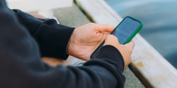 Person sjekker mobilen på en kai