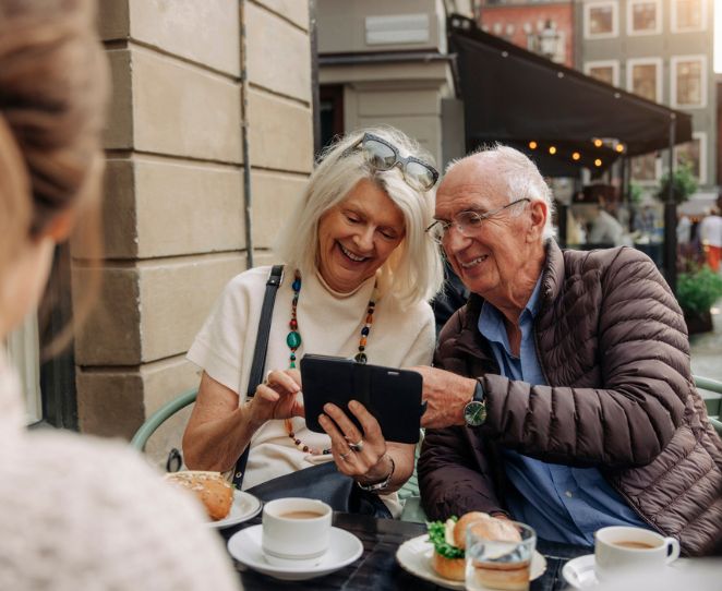 Et eldre par ser på mobiltelefonen sammen