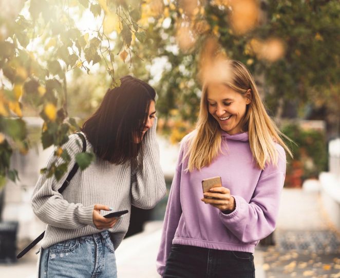 To unge kvinner ser på mobilen