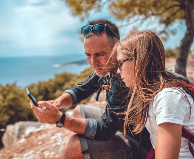 Far og datter ser på telefonen sammen