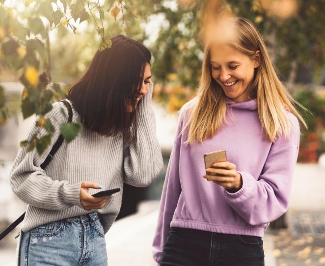 Venninner ser på mobil sammen