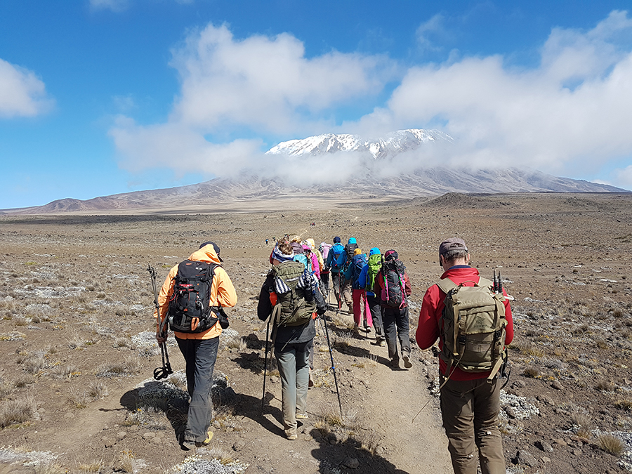 Gruppe mennesker på vei mot fjellet Kilimanjaro
