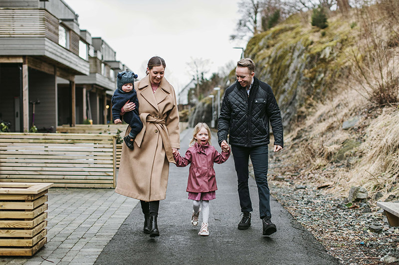 Familie på 4 er ute og går utenfor rekkehus i Bergen